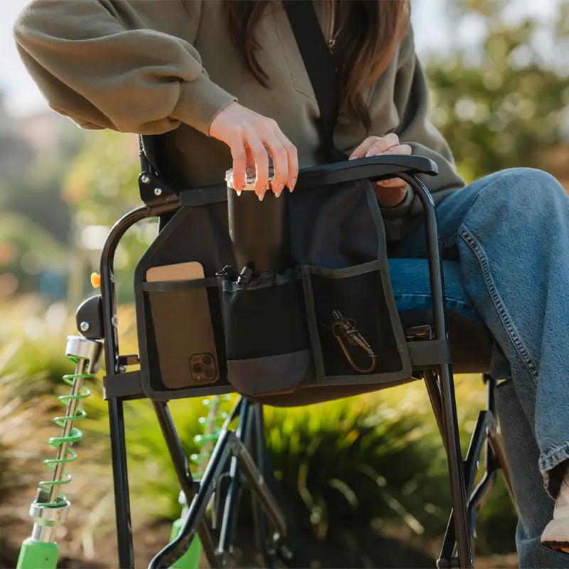 Close-up of side organizer on the Adjustable Rocker, storing a phone, tumbler, and keys.