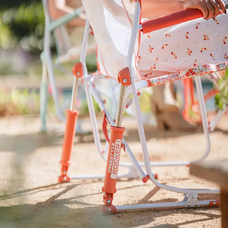 Zoomed-in view of the Freestyle Rocker’s bright red rocker springs and floral print fabric.