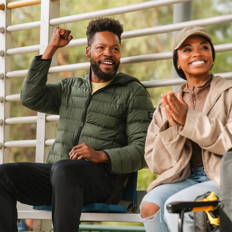 all-groups Man and woman cheering from bleachers, the man seated comfortably in a blue SitBacker seat.