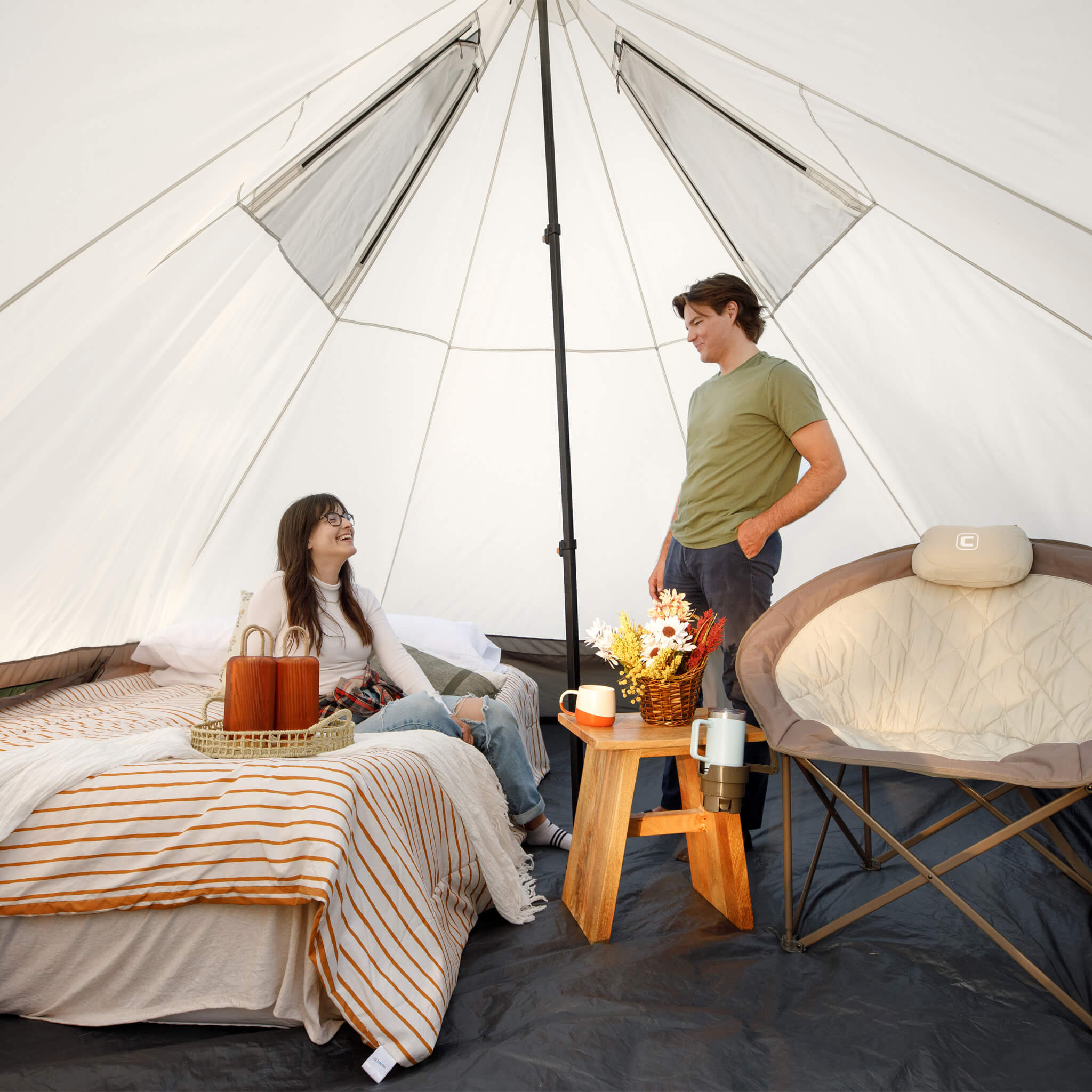 Campers inside CORE 6 person lighted bell tent with cozy setup, showing high ceiling, spacious layout, and bright interior.
