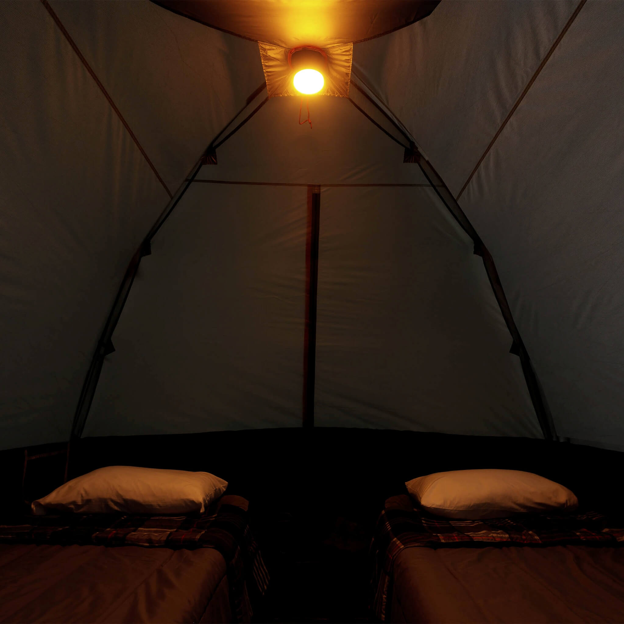Inside view of CORE 6 person lighted dome tent with two cots, dark interior, and ceiling light on amber mode providing overhead illumination.