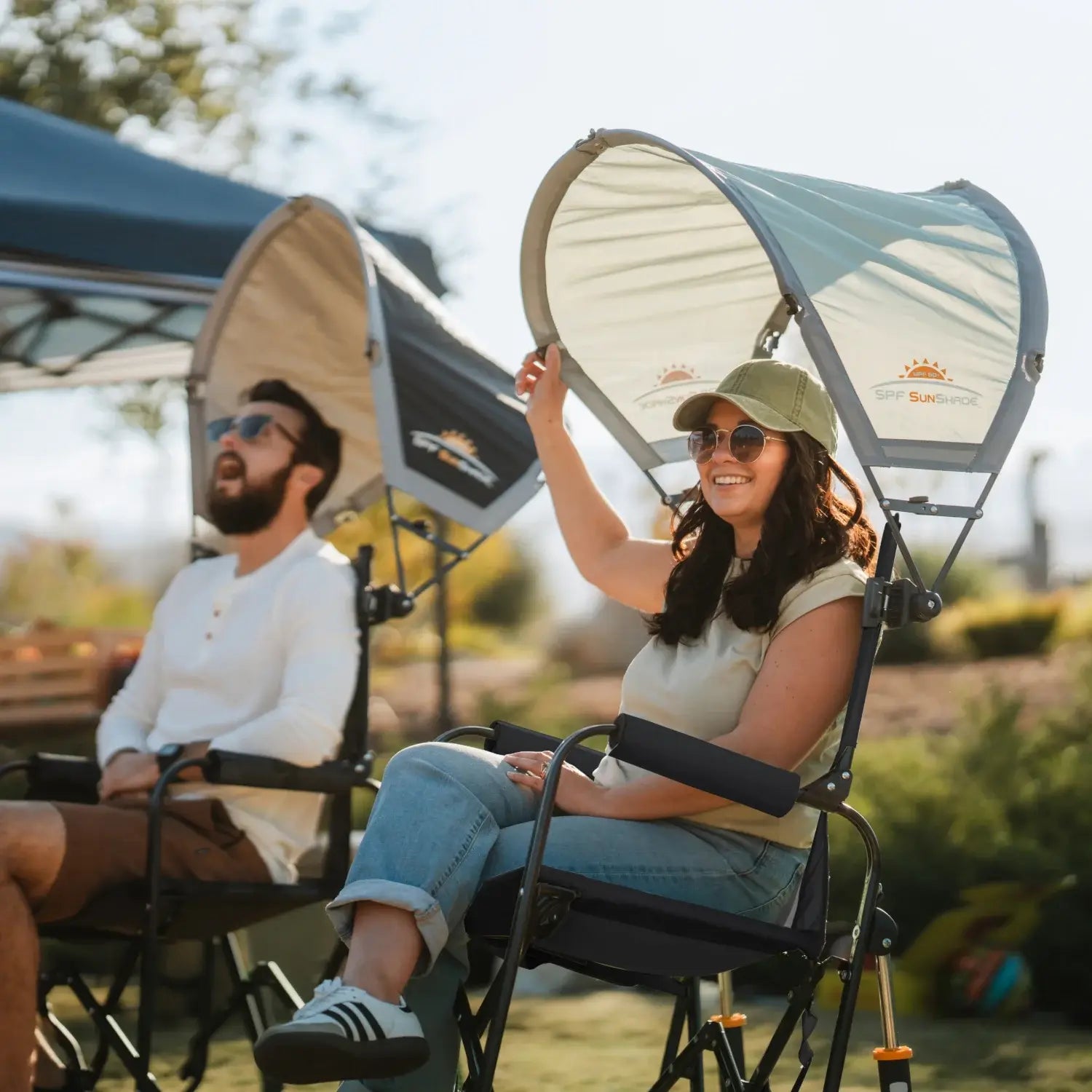 A woman sitting in a black stowaway rocker while adjusting the sunshade accessory.